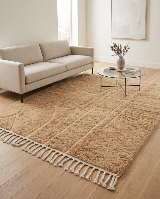 A plush camel Mrirt Moroccan rug by NURA anchors a modern living room, its carved geometric texture adding warmth and depth.