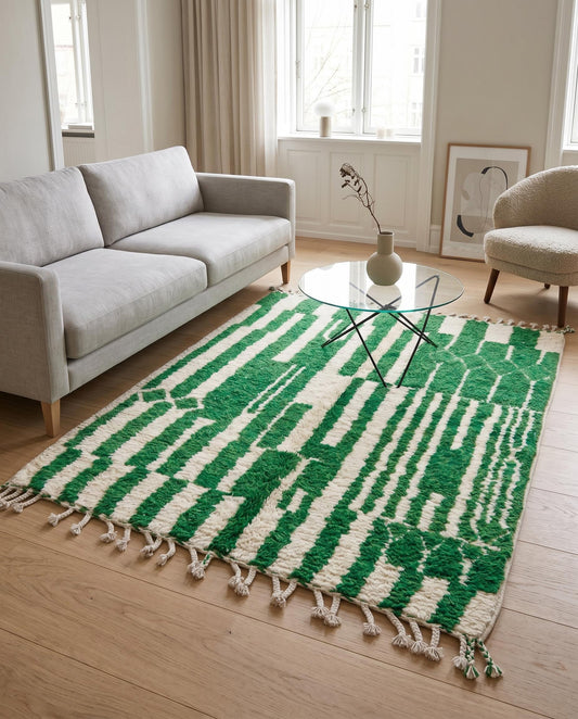 A bold green and cream geometric Moroccan rug styled in a modern living room with contemporary furniture, by NURA.