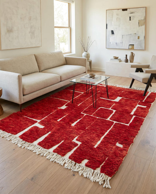 A vibrant red Moroccan rug by NURA with an abstract block pattern, styled in a modern living room with warm natural light.