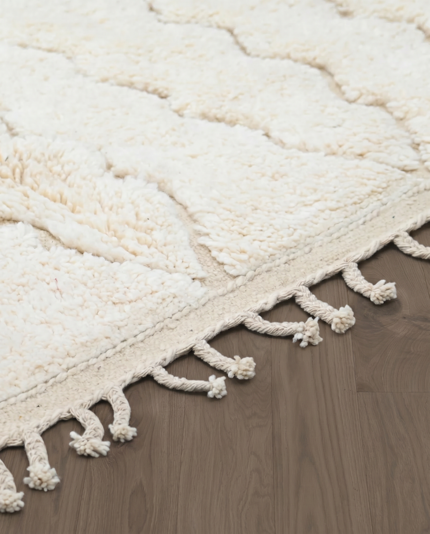 GHAZALA Beni Ourain cream diamond lattice Moroccan rug close-up of hand-tied fringe and kilim band detail, by NURA