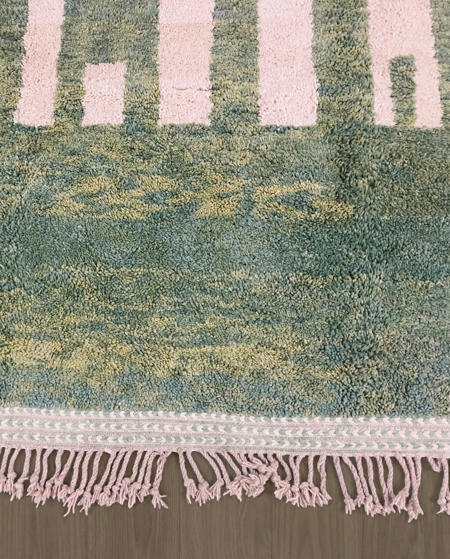 MANAL Mrirt sage asymmetrical color block Moroccan rug close-up of hand-tied fringe and kilim band detail 2, by NURA