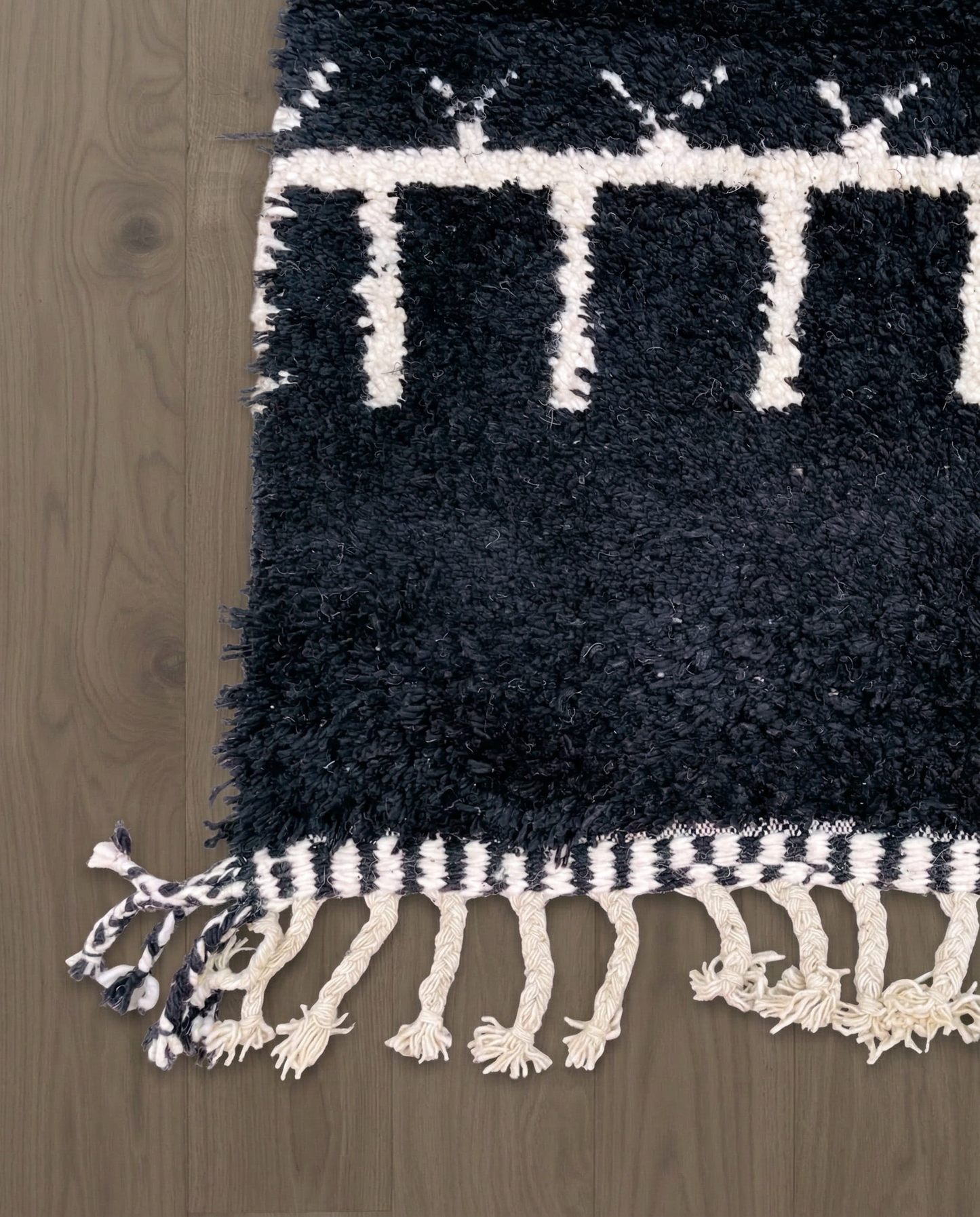 ZOHRA Beni Ourain black horizontal geometric bands Moroccan rug close-up of hand-tied fringe and kilim band detail, by NURA
