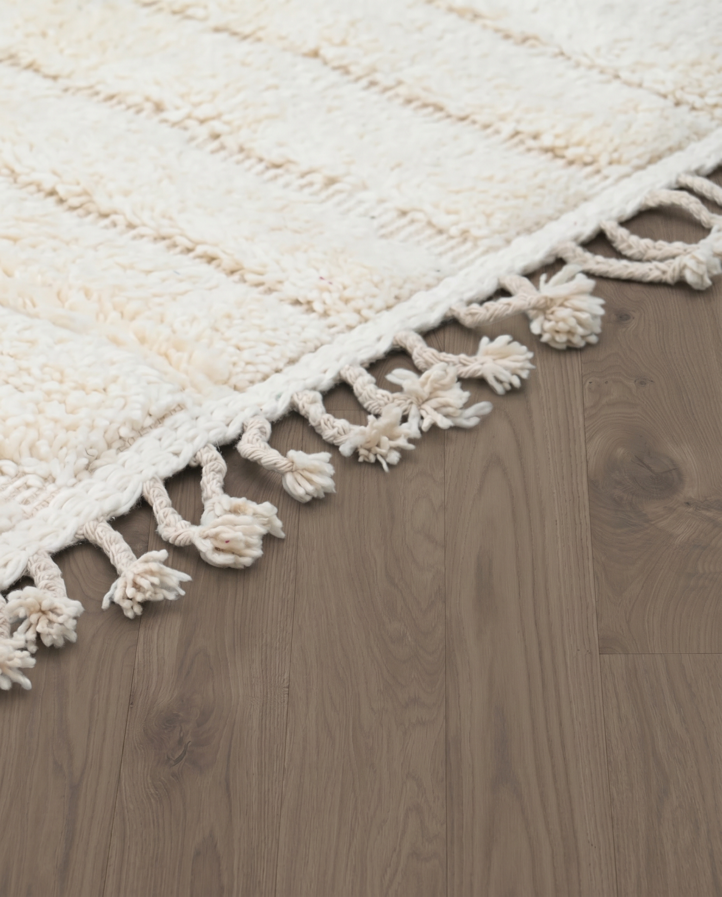 ABLA Beni Ourain cream geometric maze Moroccan rug close-up of hand-tied fringe and kilim band detail, by NURA