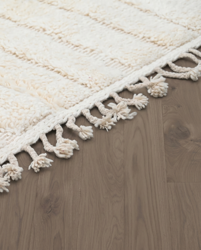 ABLA Beni Ourain cream geometric maze Moroccan rug close-up of hand-tied fringe and kilim band detail, by NURA