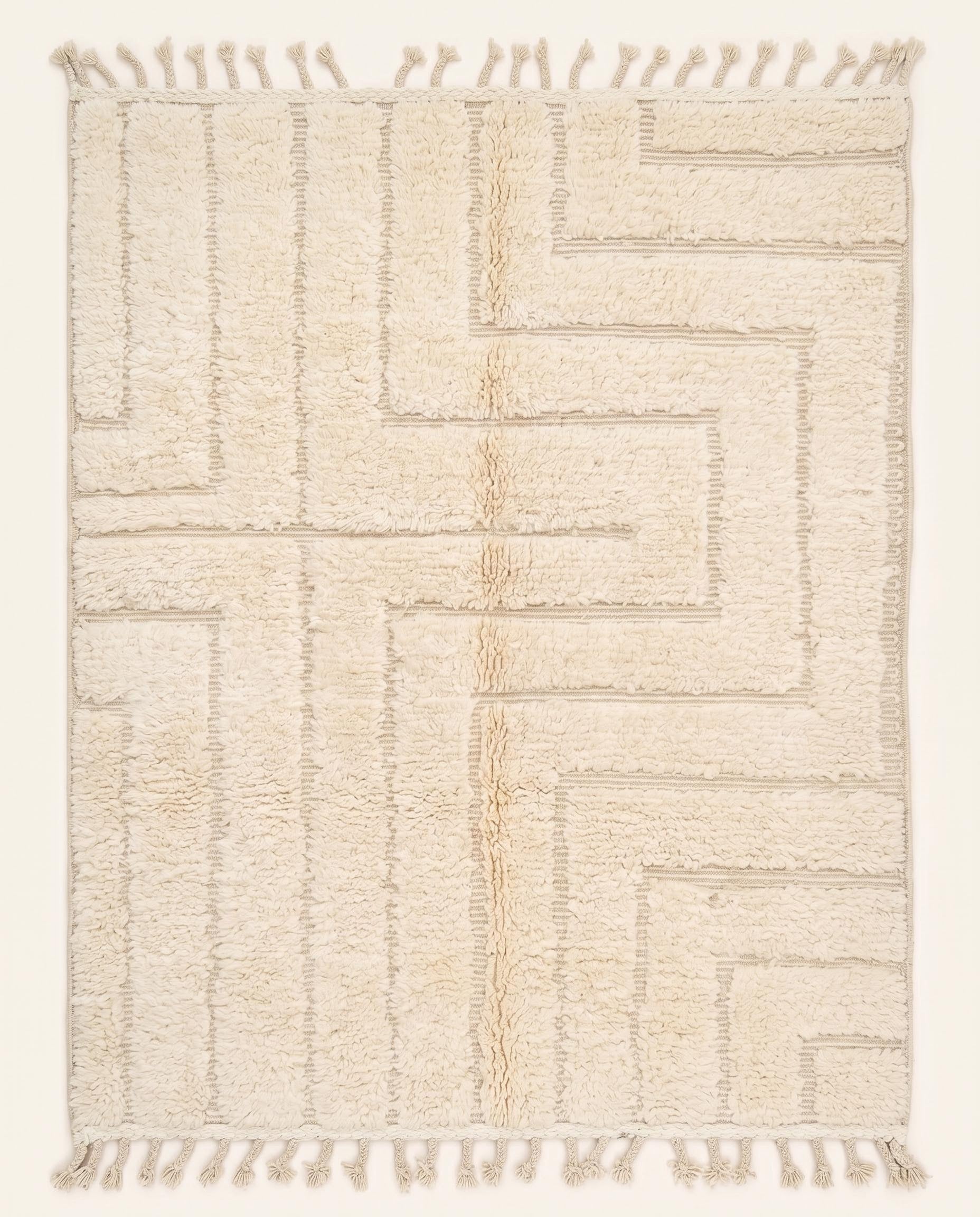 A contemporary Moroccan rug featuring a sculptural high-low geometric maze pattern in solid cream wool, crafted by NURA.