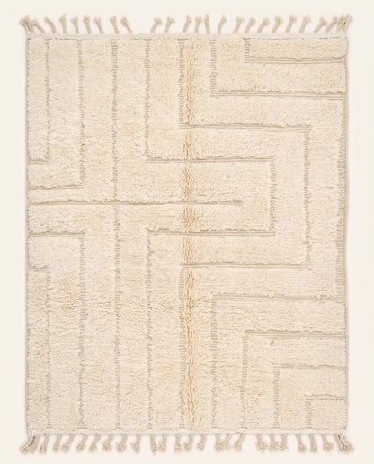 A contemporary Moroccan rug featuring a sculptural high-low geometric maze pattern in solid cream wool, crafted by NURA.