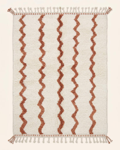 Hand-knotted Beni Ourain Moroccan rug featuring a plush cream wool pile with vertical wavy terracotta lines, by NURA.