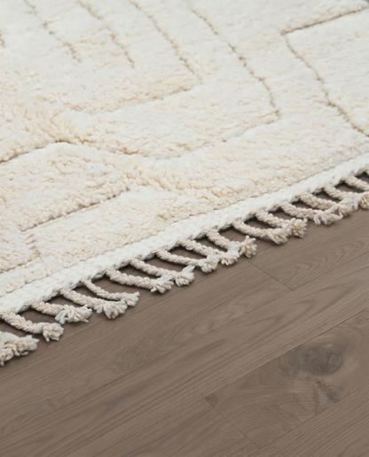 AFRAH Beni Ourain cream organic abstract Moroccan rug close-up of hand-tied fringe and kilim band detail 1, by NURA