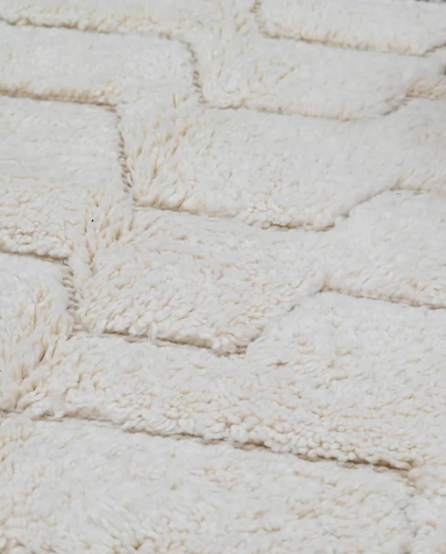 AFRAH Beni Ourain cream organic abstract Moroccan rug close-up showing hand-knotted wool texture and pile detail 1, by NURA