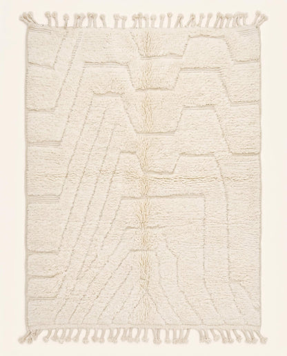 A plush cream Beni Ourain Moroccan rug featuring a subtle carved geometric design in a tonal monochromatic palette by NURA.