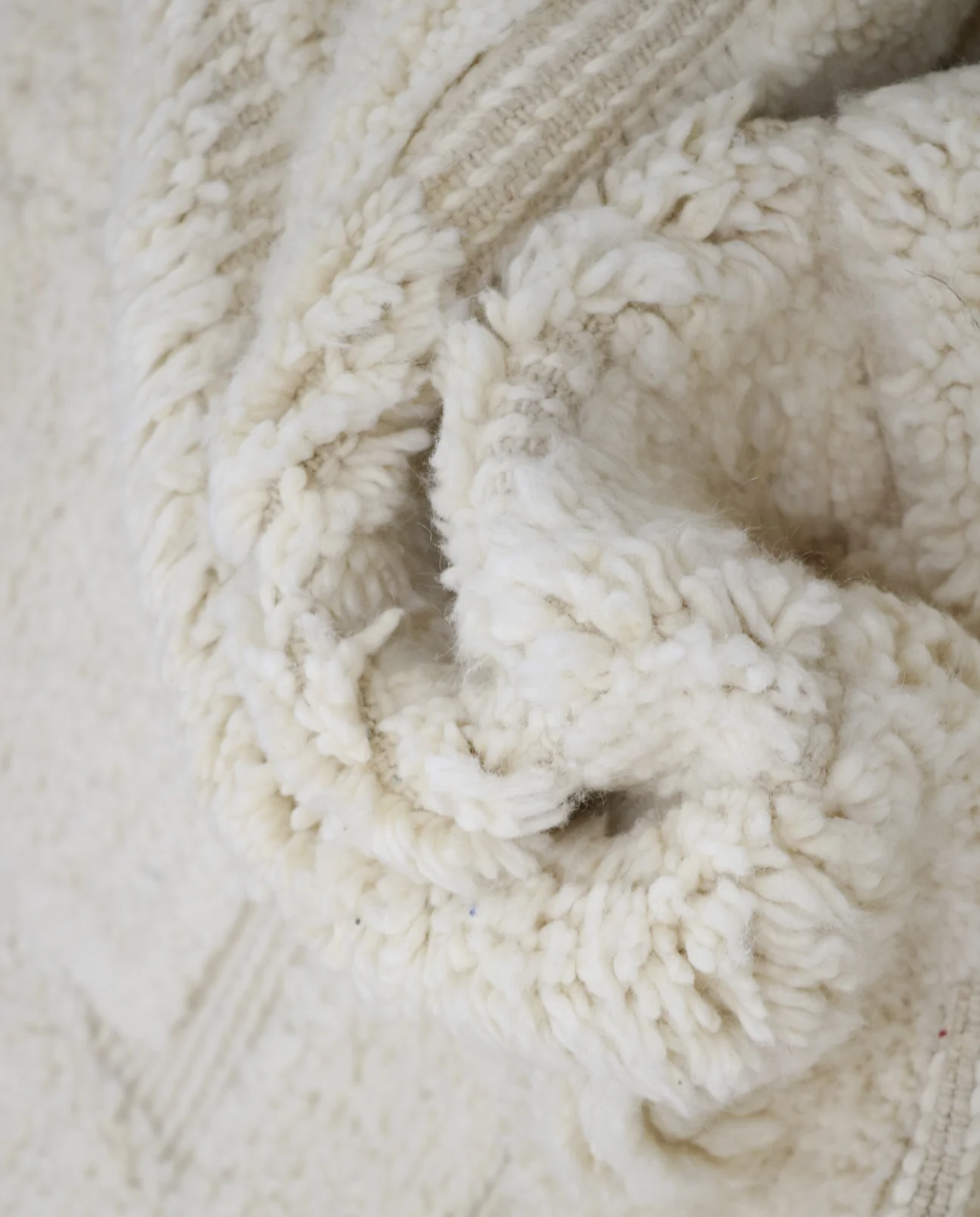AKILA Beni Ourain cream organic abstract Moroccan rug close-up showing hand-knotted wool texture and pile detail, by NURA