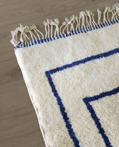 AMINA Beni Ourain cream nested border medallion Moroccan rug close-up of hand-tied fringe and kilim band detail, by NURA