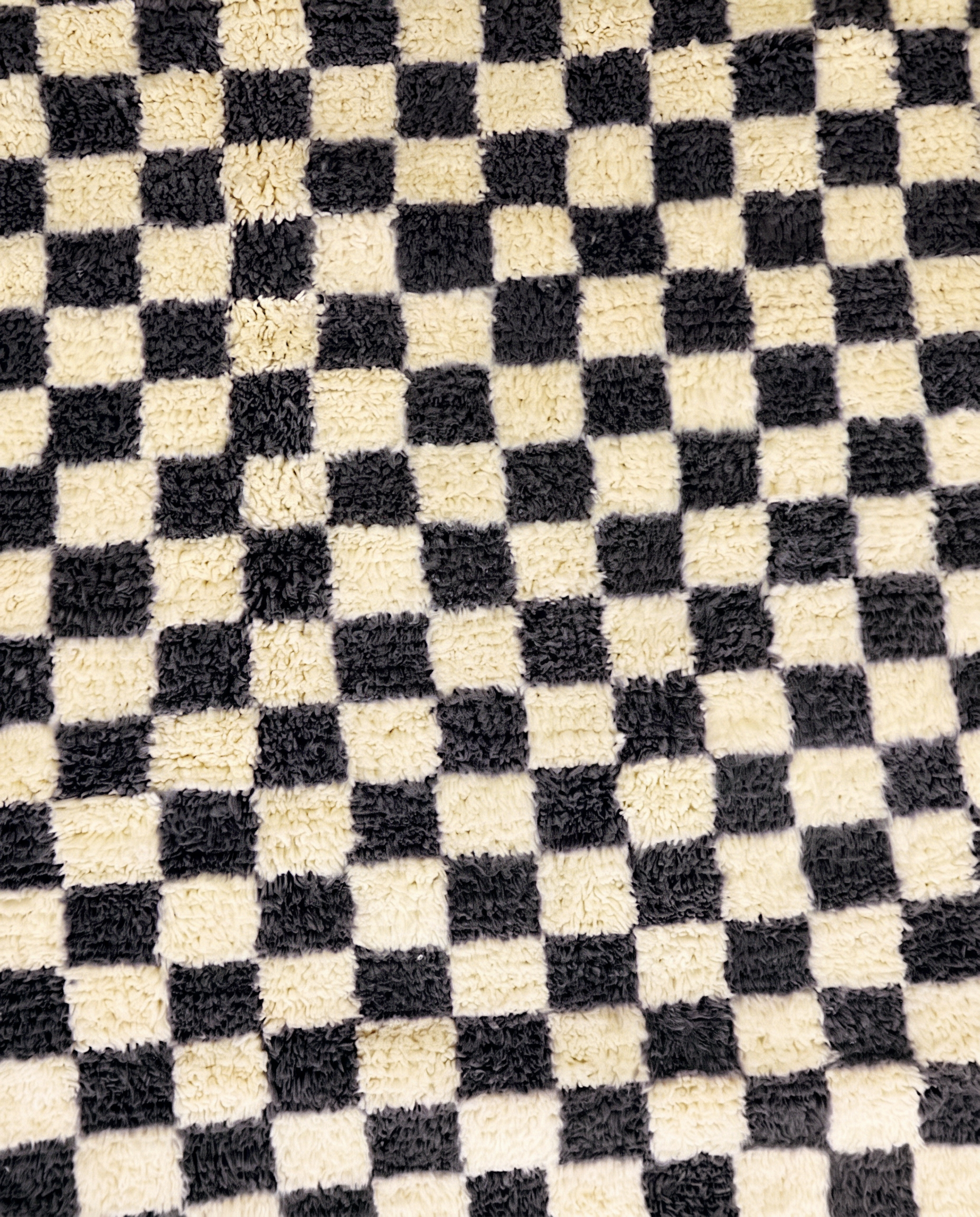 ANISSA Beni Ourain black checkerboard grid Moroccan rug close-up showing hand-knotted wool texture and pile detail 1, by NURA