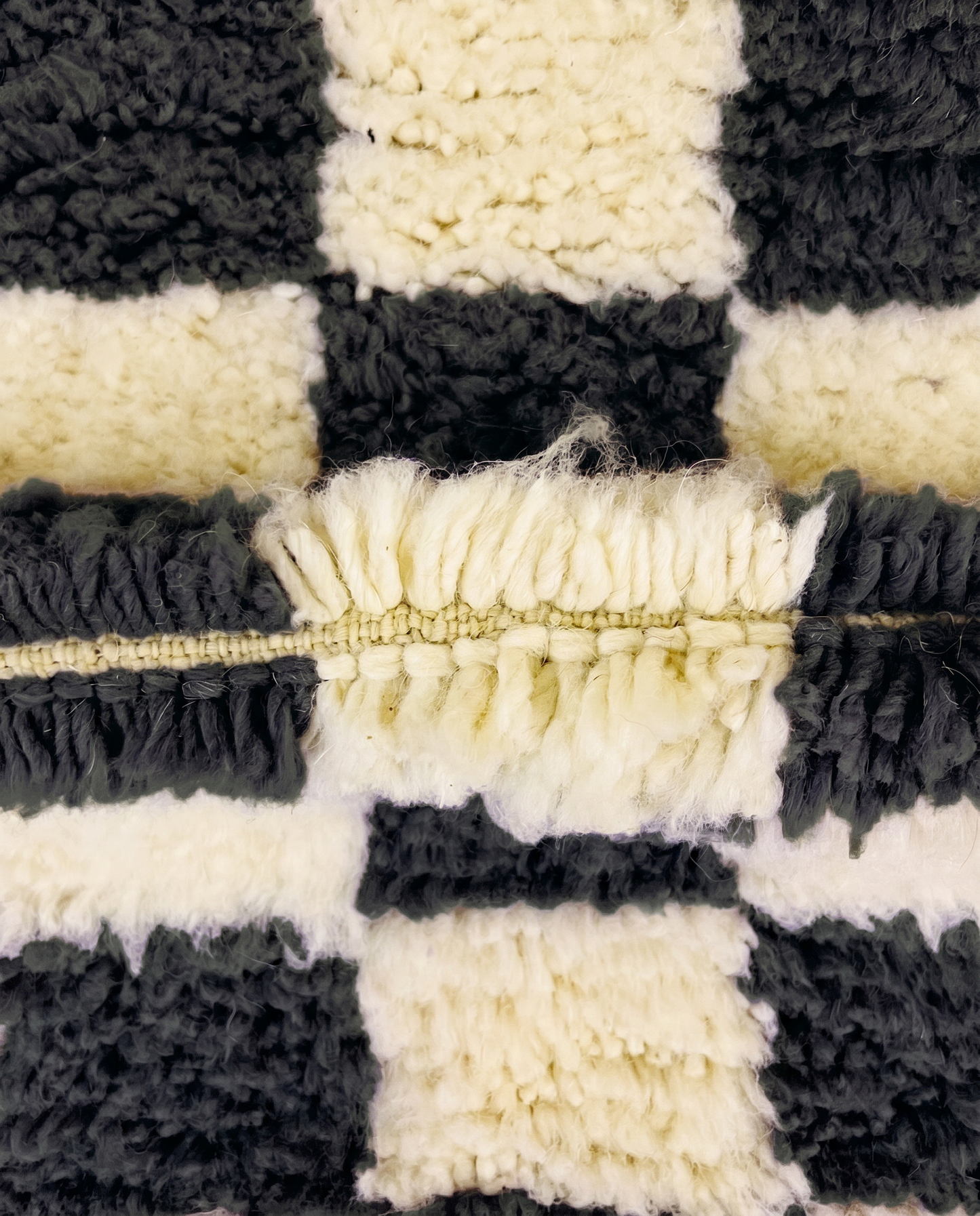 ANISSA Beni Ourain black checkerboard grid Moroccan rug close-up showing hand-knotted wool texture and pile detail 3, by NURA