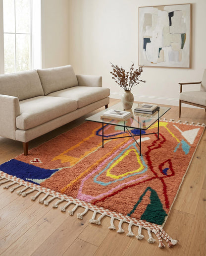 Vibrant terracotta Boujad Moroccan rug with colorful organic abstract shapes styled in a bright, modern living room by NURA.