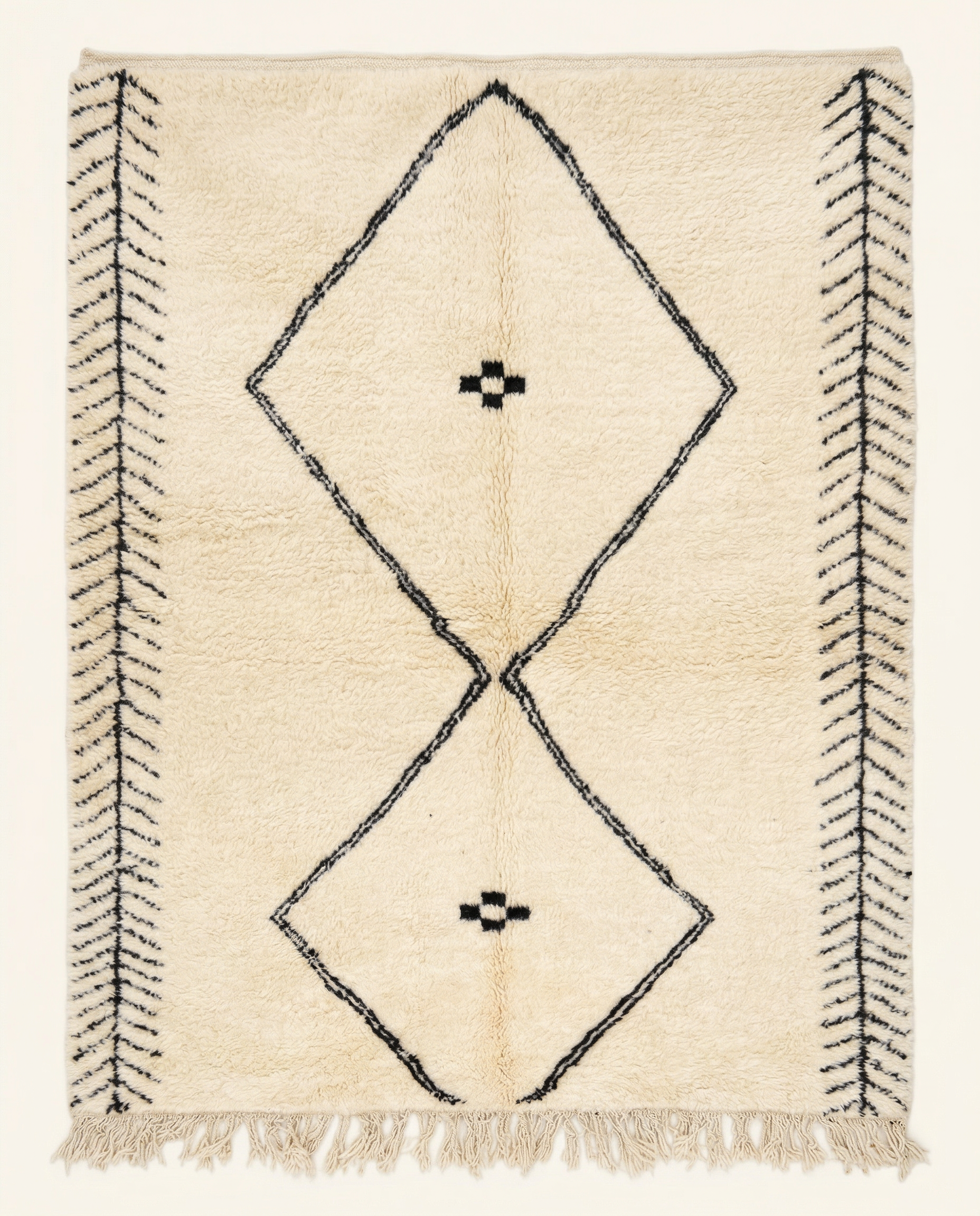 Plush cream Beni Ourain Moroccan rug with a large black double diamond motif and herringbone end bands, by NURA.