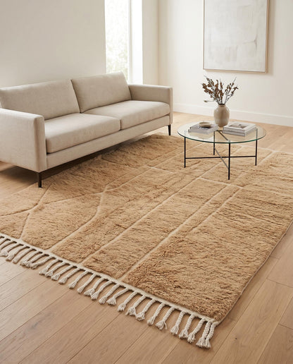 A plush camel Mrirt Moroccan rug by NURA anchors a modern living room, its carved geometric texture adding warmth and depth.