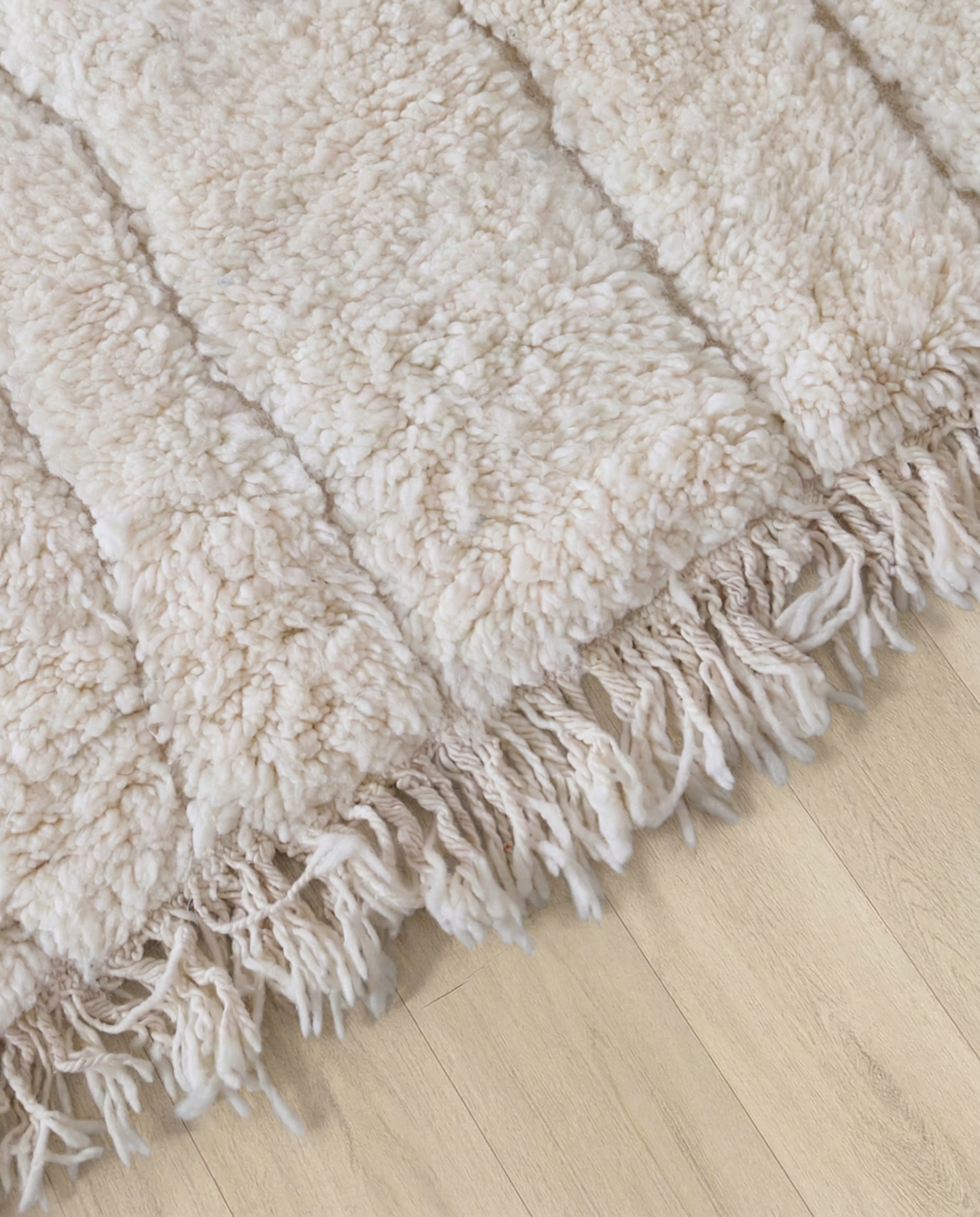AYA Beni Ourain cream carved linear grid Moroccan rug close-up of hand-tied fringe and kilim band detail, by NURA