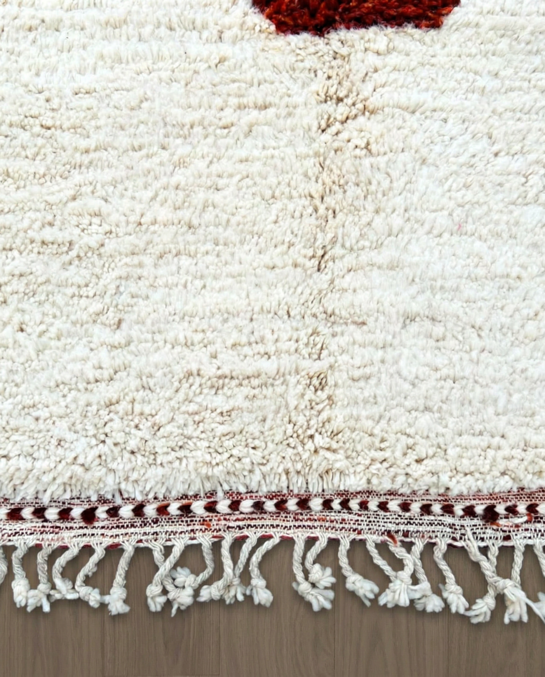 BASMA Beni Ourain cream stacked abstract motifs Moroccan rug close-up of hand-tied fringe and kilim band detail, by NURA