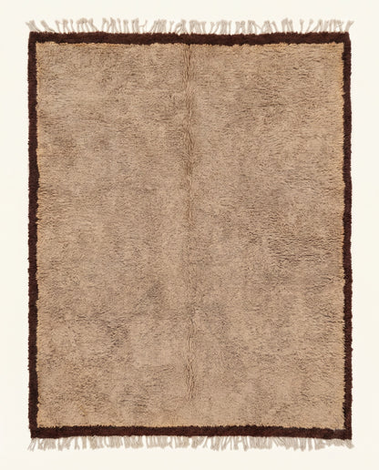 Plush tan Beni Ourain Moroccan rug featuring a thick chocolate brown border, hand-knotted from virgin wool by NURA.