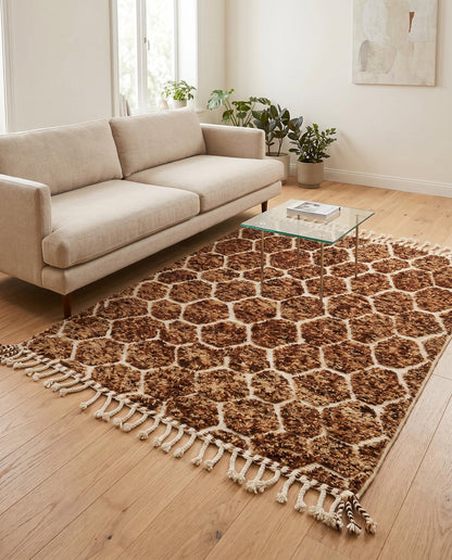 Plush brown and cream geometric Moroccan rug styled in a warm, modern living room with natural wood furniture, by NURA.