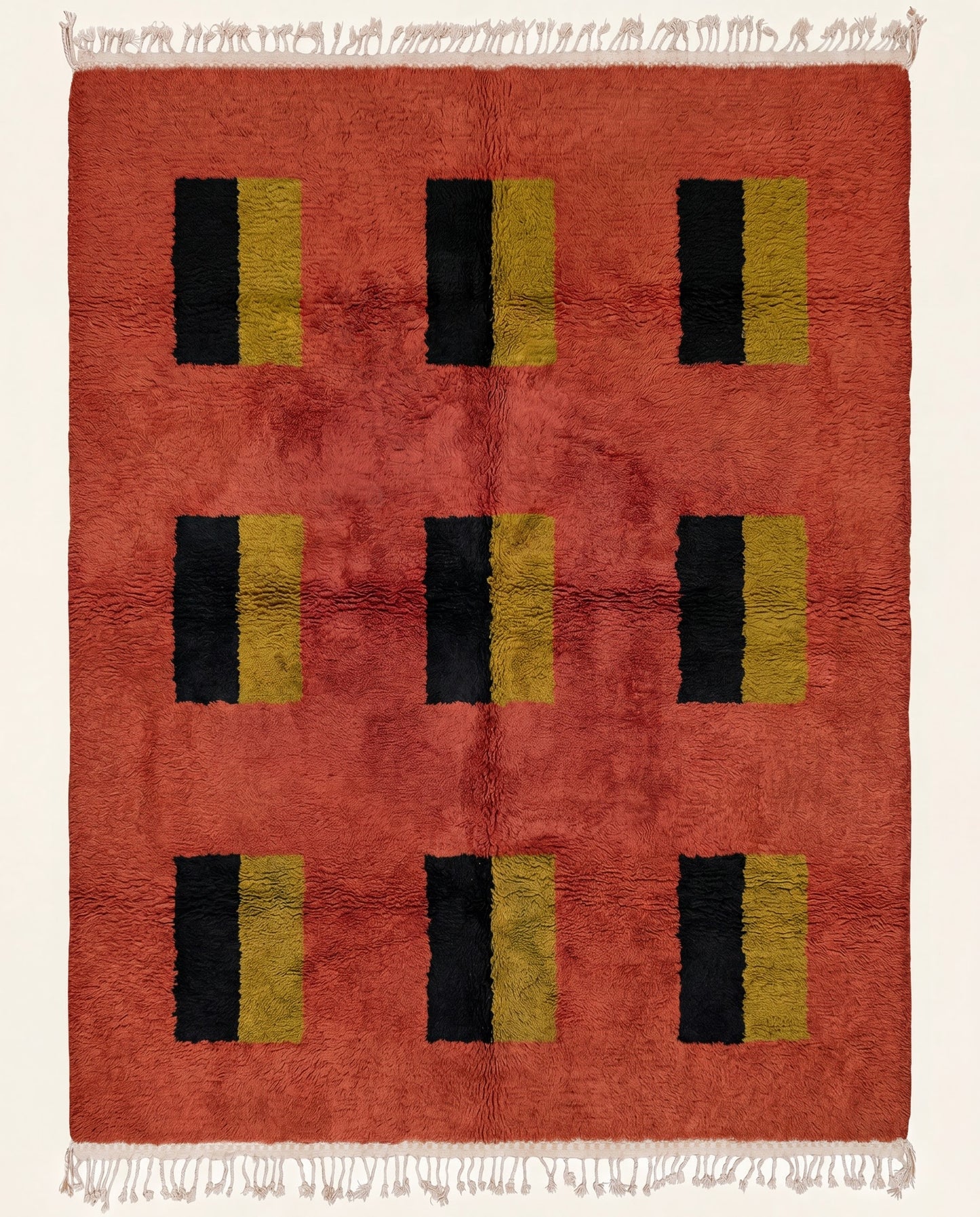 A plush Moroccan wool rug featuring a rich terracotta field with a modern grid of black and mustard yellow color blocks by NURA.