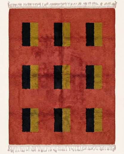 A plush Moroccan wool rug featuring a rich terracotta field with a modern grid of black and mustard yellow color blocks by NURA.