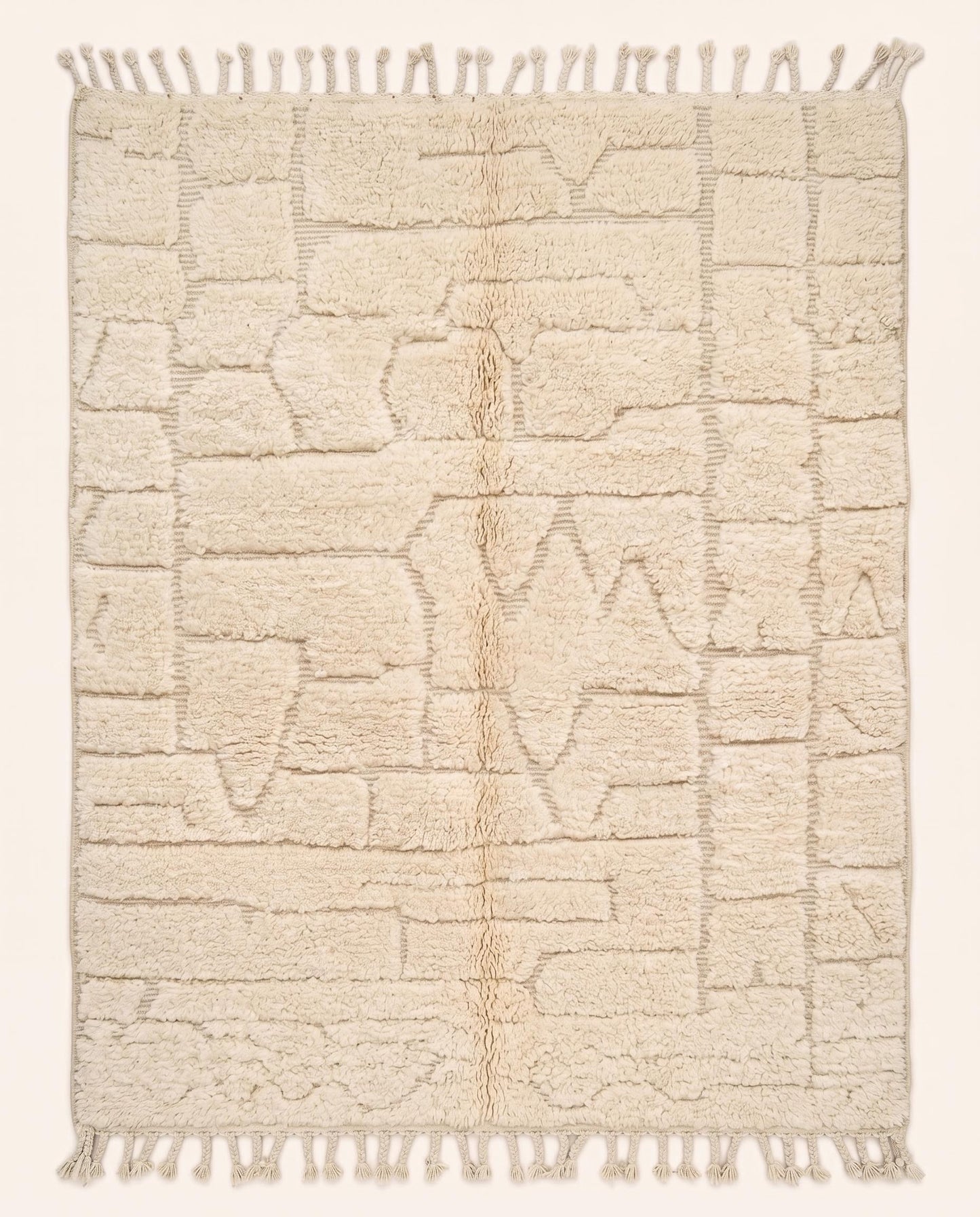A plush cream Moroccan rug featuring a carved high-low pile with abstract geometric shapes, hand-knotted in pure wool by NURA.