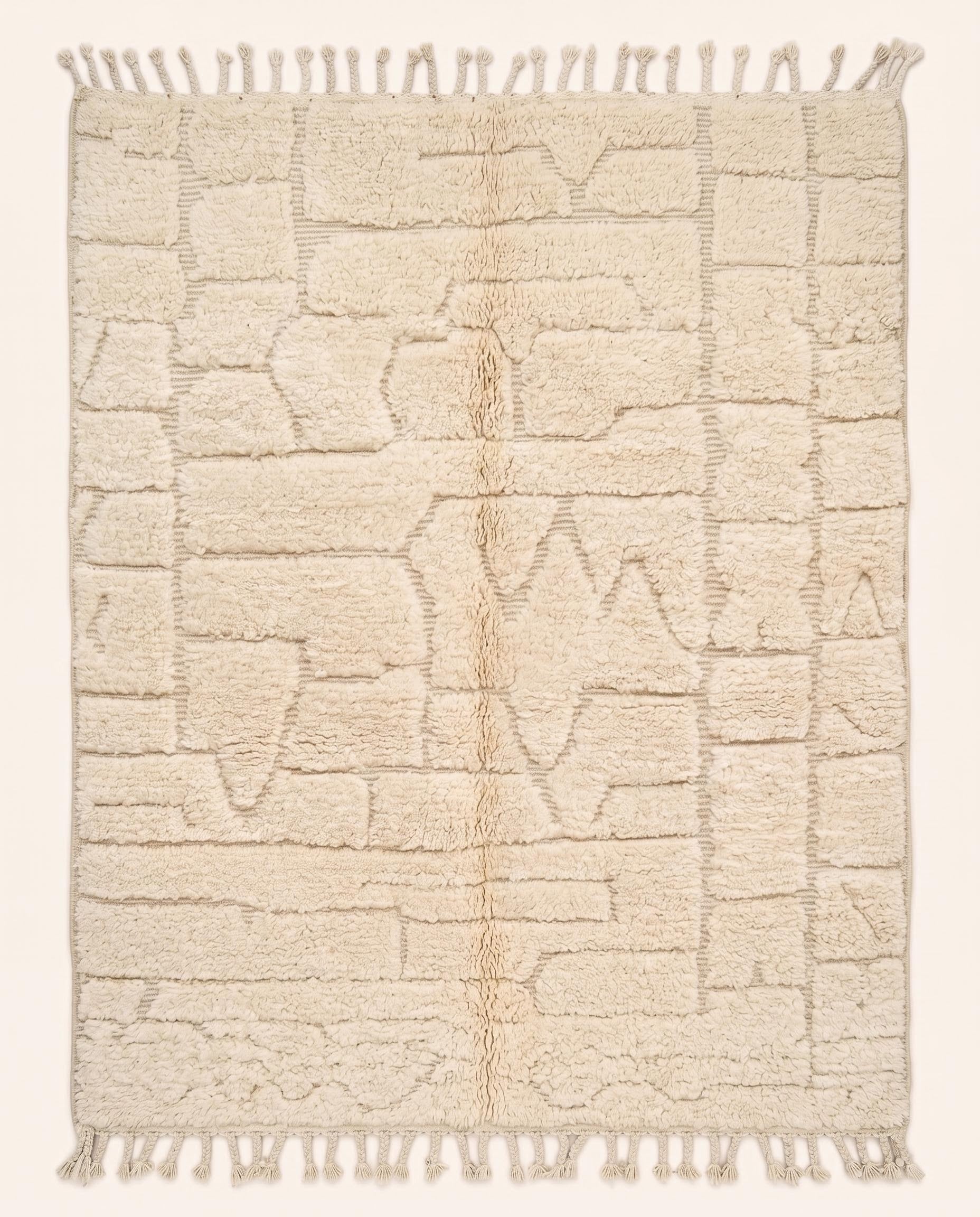 A plush cream Moroccan rug featuring a carved high-low pile with abstract geometric shapes, hand-knotted in pure wool by NURA.