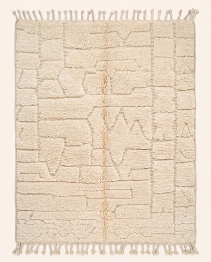 A plush cream Moroccan rug featuring a carved high-low pile with abstract geometric shapes, hand-knotted in pure wool by NURA.