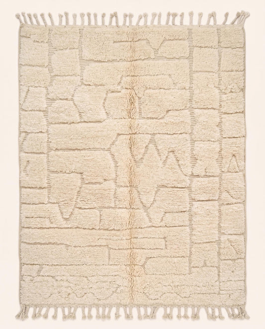 A plush cream Moroccan rug featuring a carved high-low pile with abstract geometric shapes, hand-knotted in pure wool by NURA.