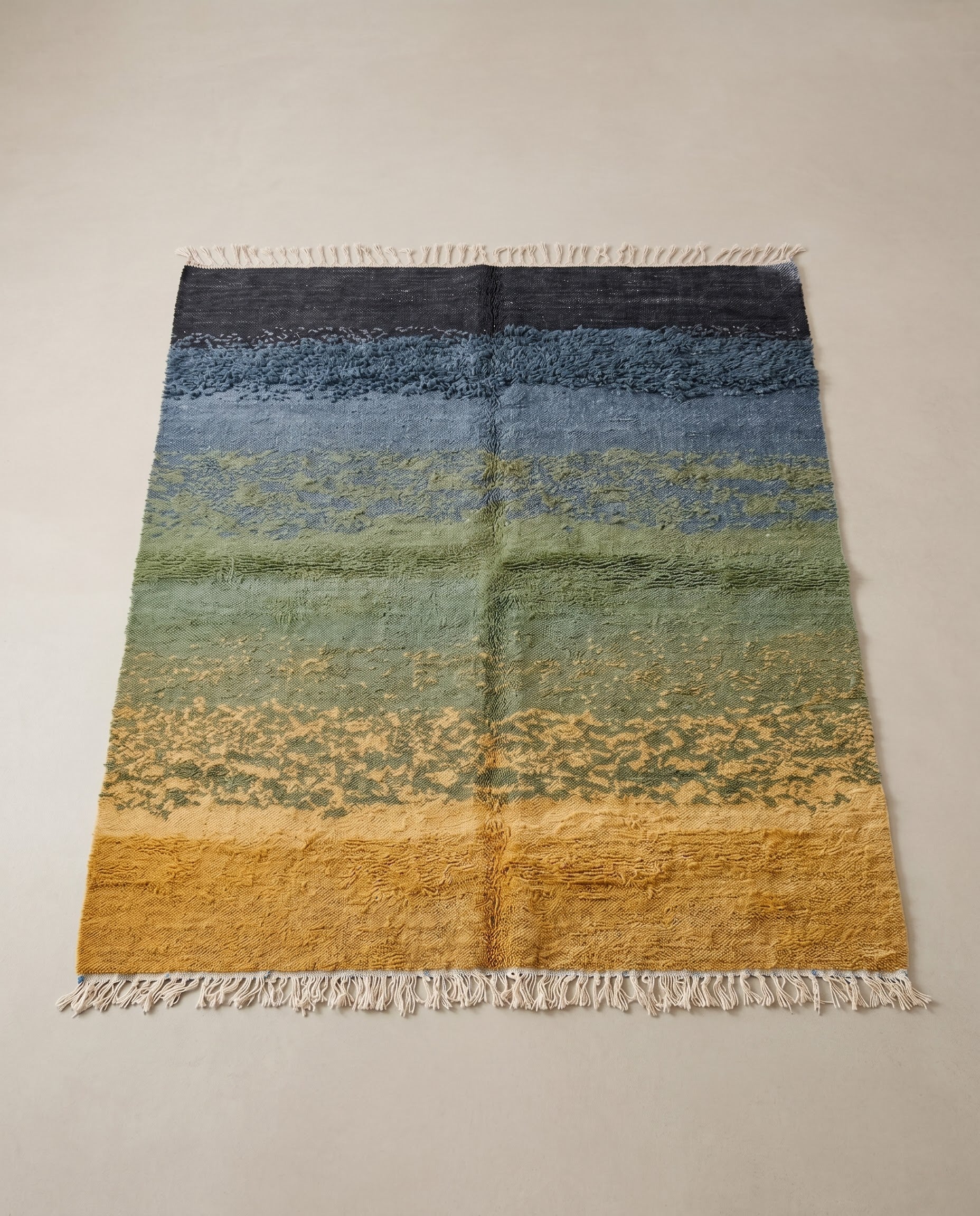 CHAIMA Azilal mustard abstract landscape Moroccan rug displayed on a parquet wood floor, showing full fringe and edge detail, by NURA