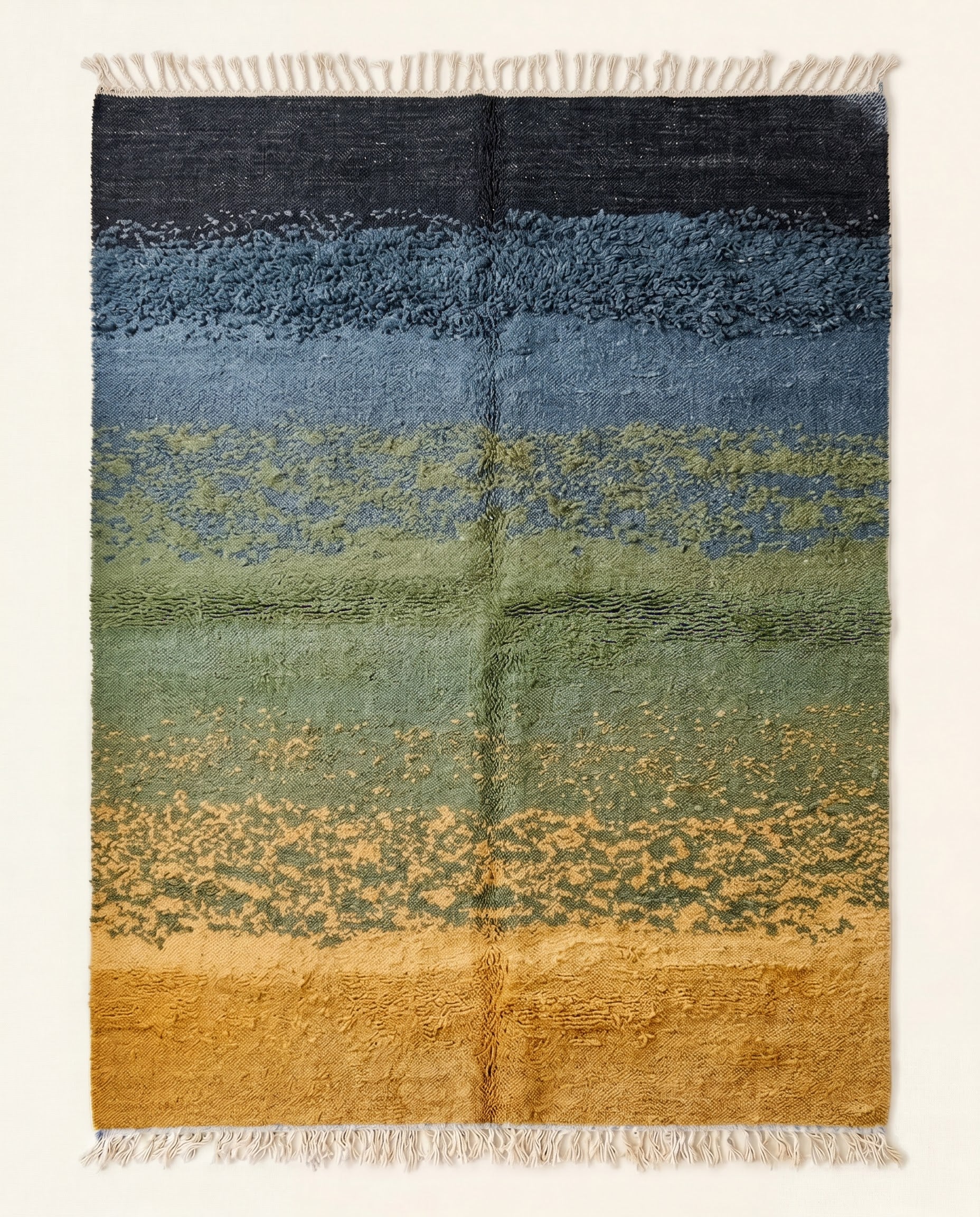 A contemporary Moroccan rug featuring an abstract landscape design with horizontal ombré bands of mustard, sage, denim, and black.