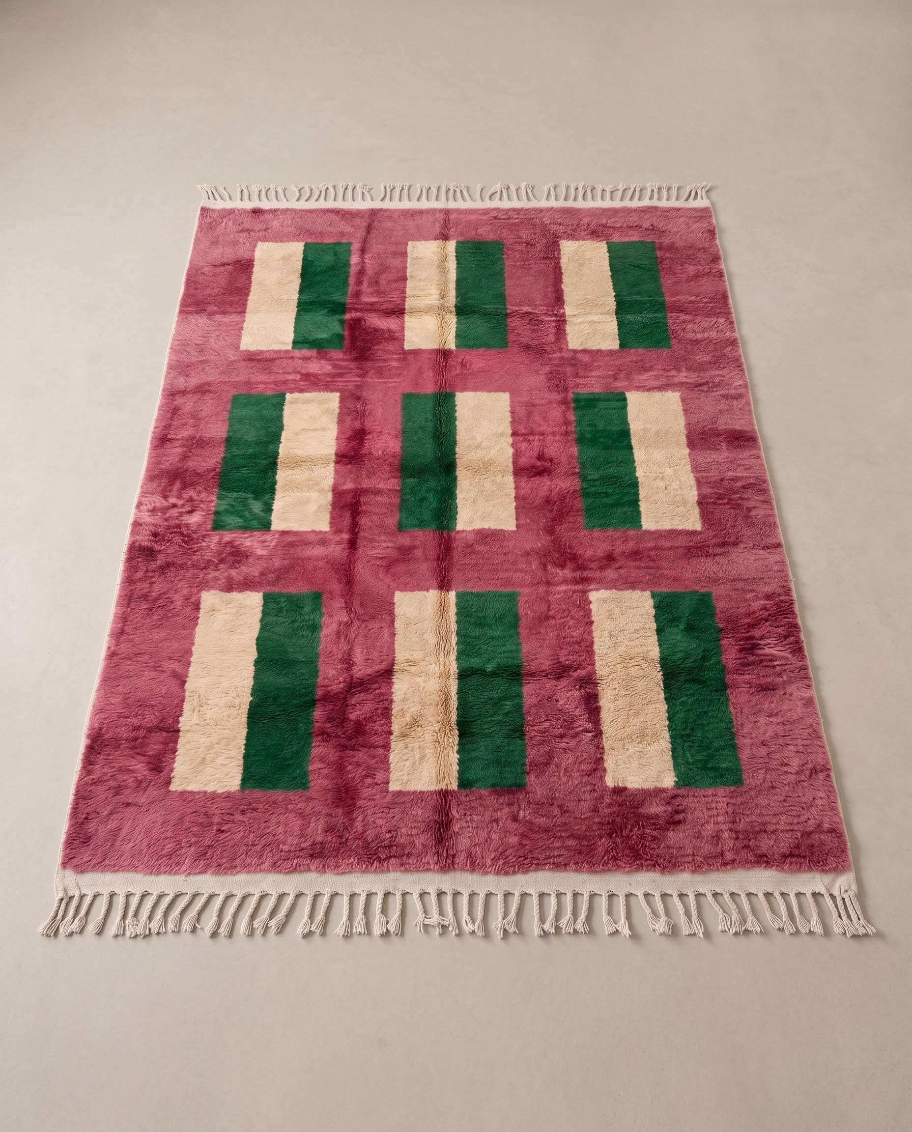 CHAMA Boujad rose color block Moroccan rug displayed on a parquet wood floor, showing full fringe and edge detail, by NURA