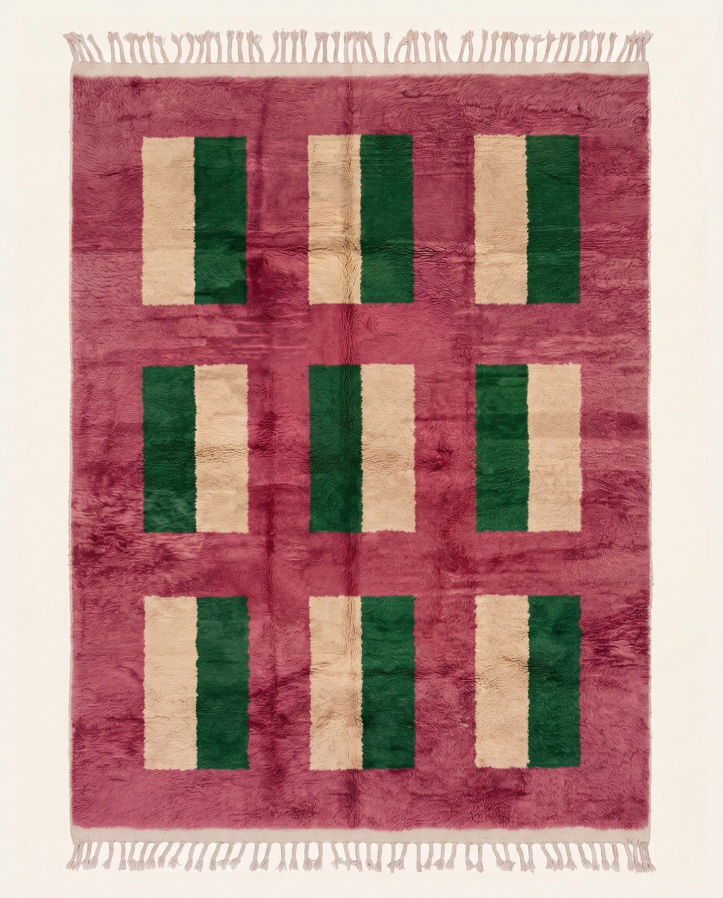 A plush contemporary Moroccan wool rug featuring a bold color block grid in dark green and cream on a vibrant rose field by NURA.