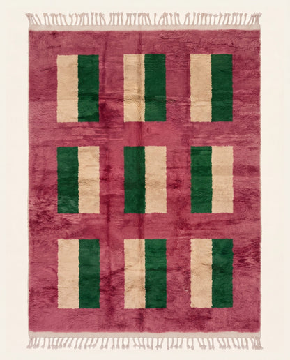 A plush contemporary Moroccan wool rug featuring a bold color block grid in dark green and cream on a vibrant rose field by NURA.
