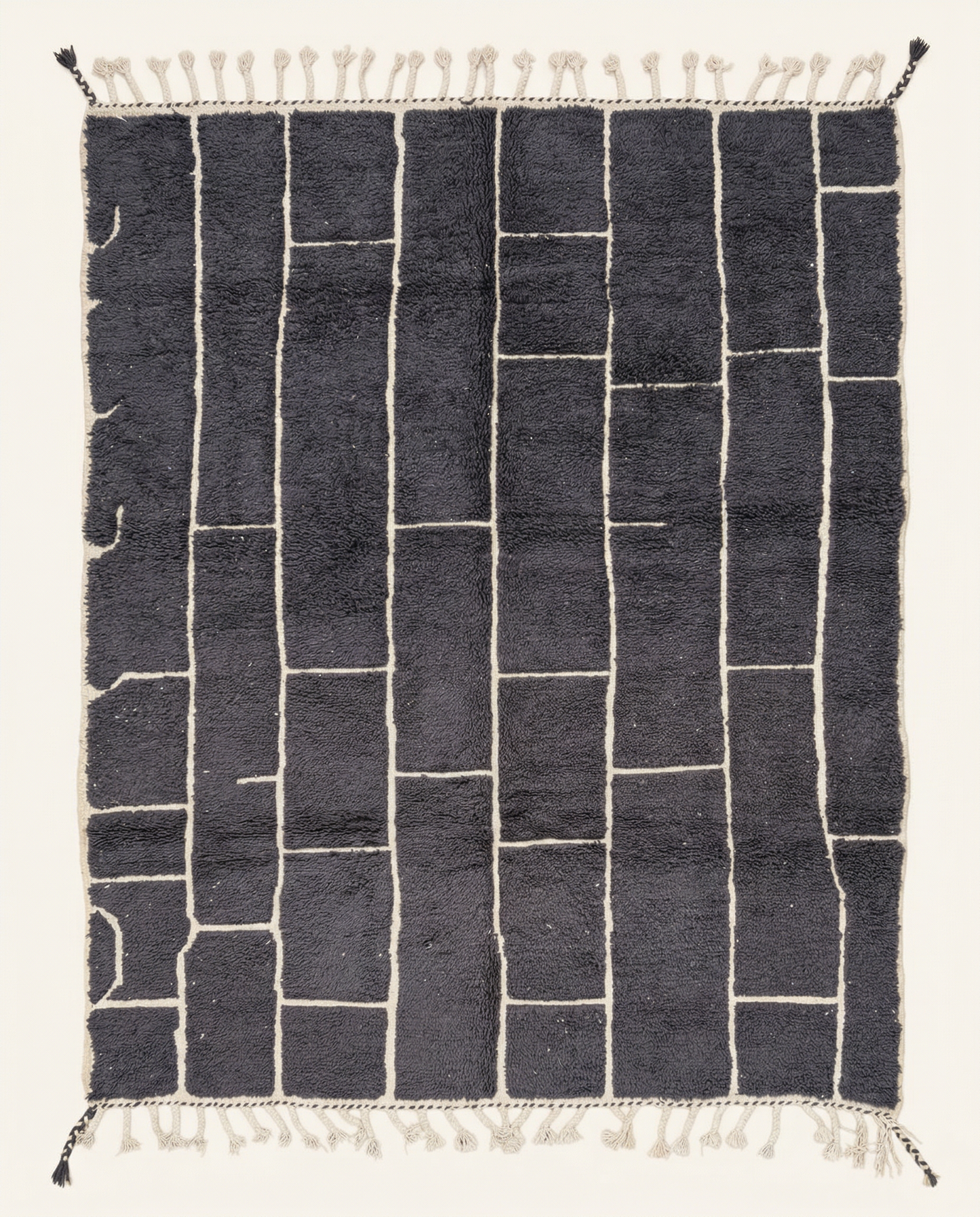 Plush charcoal Beni Ourain Moroccan rug with a bold ivory irregular block grid and a thick high pile, by NURA.
