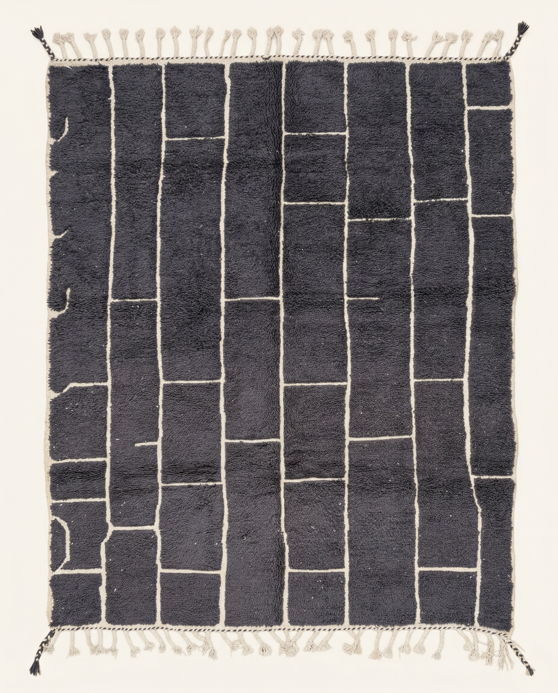 Plush charcoal Beni Ourain Moroccan rug with a bold ivory irregular block grid and a thick high pile, by NURA.