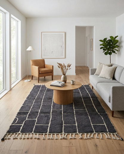 Charcoal and ivory block grid Moroccan rug standing in a bright modern space with a green plant, by NURA.