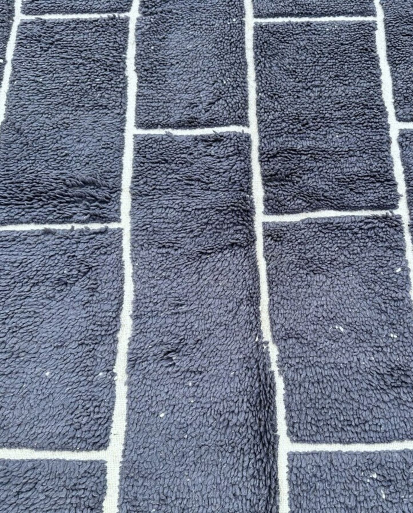 DANIA Beni Ourain charcoal irregular block grid Moroccan rug close-up showing hand-knotted wool texture and pile detail, by NURA