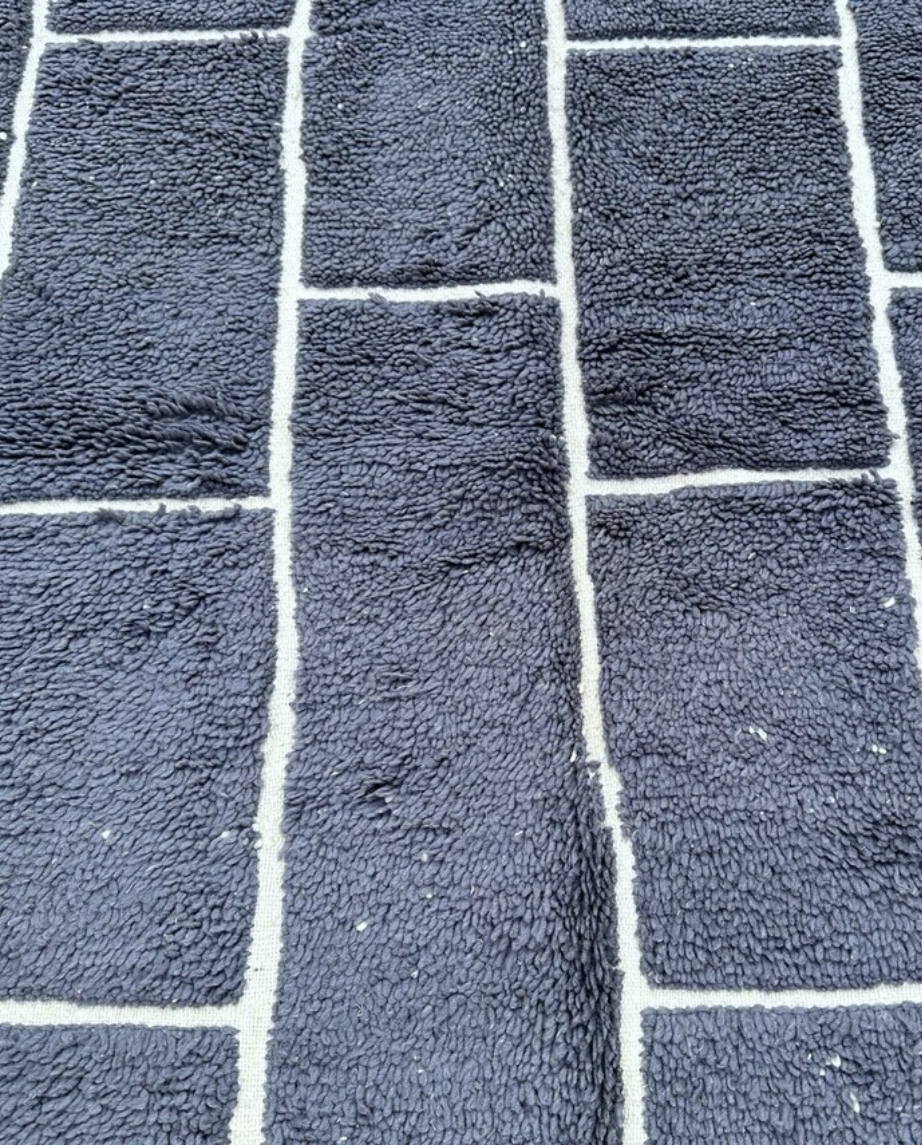 DANIA Beni Ourain charcoal irregular block grid Moroccan rug close-up showing hand-knotted wool texture and pile detail, by NURA