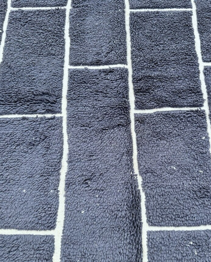 DANIA Beni Ourain charcoal irregular block grid Moroccan rug close-up showing hand-knotted wool texture and pile detail, by NURA
