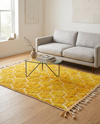 A bright mustard yellow honeycomb Moroccan rug by NURA styled in a modern living room, adding warm texture to the floor.