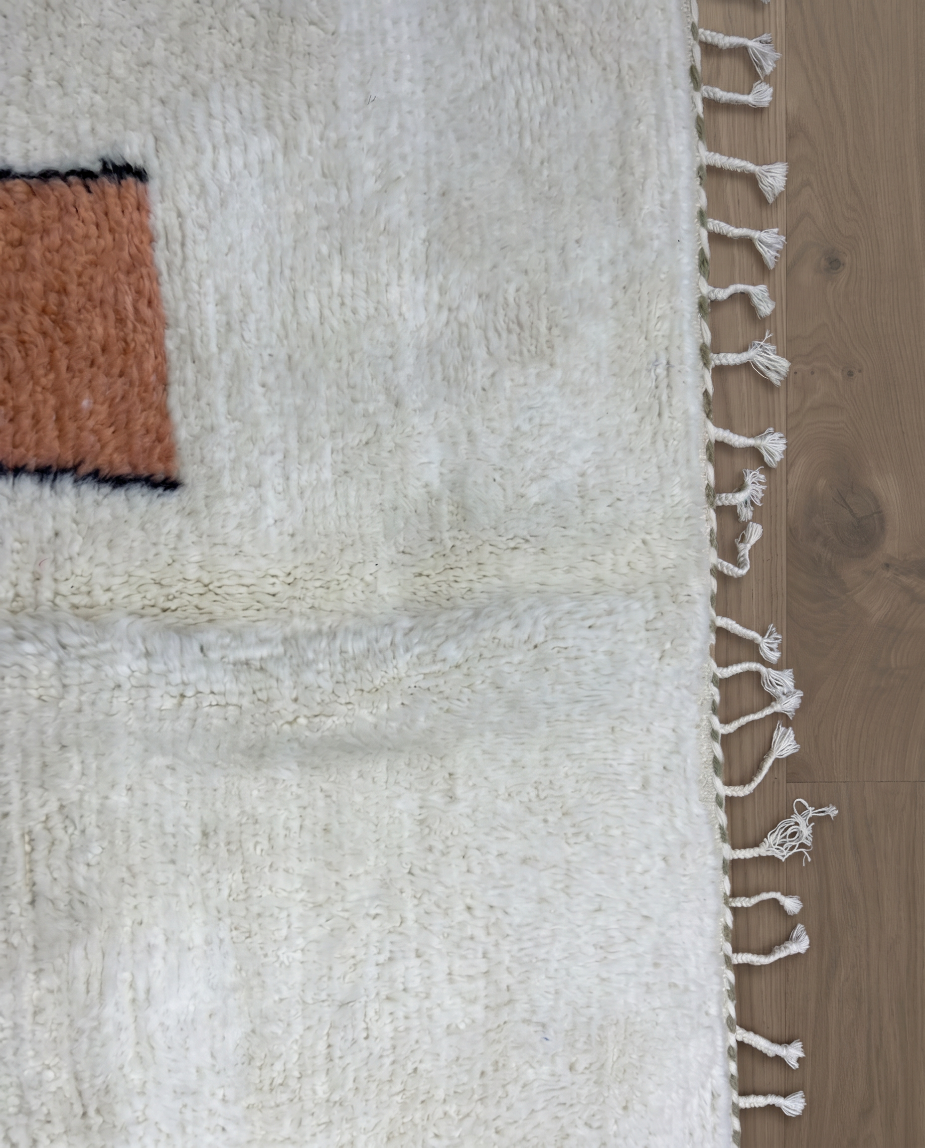 FADWA Azilal ivory abstract figurative motif Moroccan rug close-up of hand-tied fringe and kilim band detail, by NURA