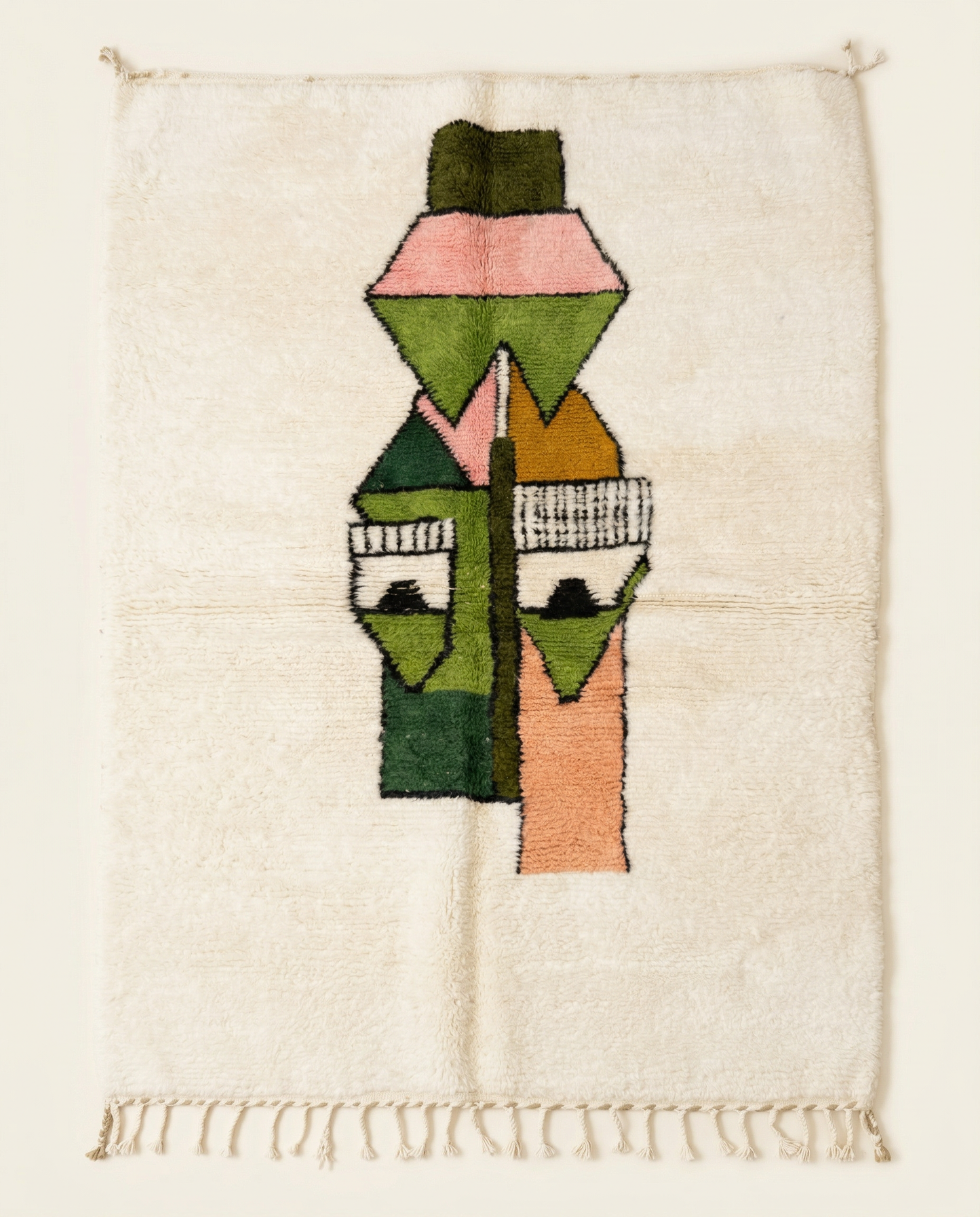 Plush ivory Azilal Moroccan rug featuring a bold, playful abstract face motif in green, peach, and pink, with a thick high pile, by NURA.