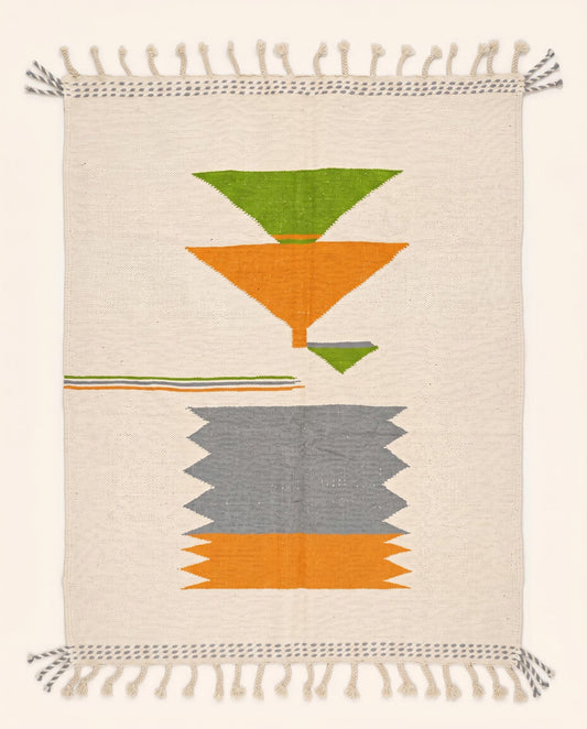 A flatwoven Moroccan kilim rug featuring bold orange, grey, and green geometric color blocks on a cream wool background by NURA.