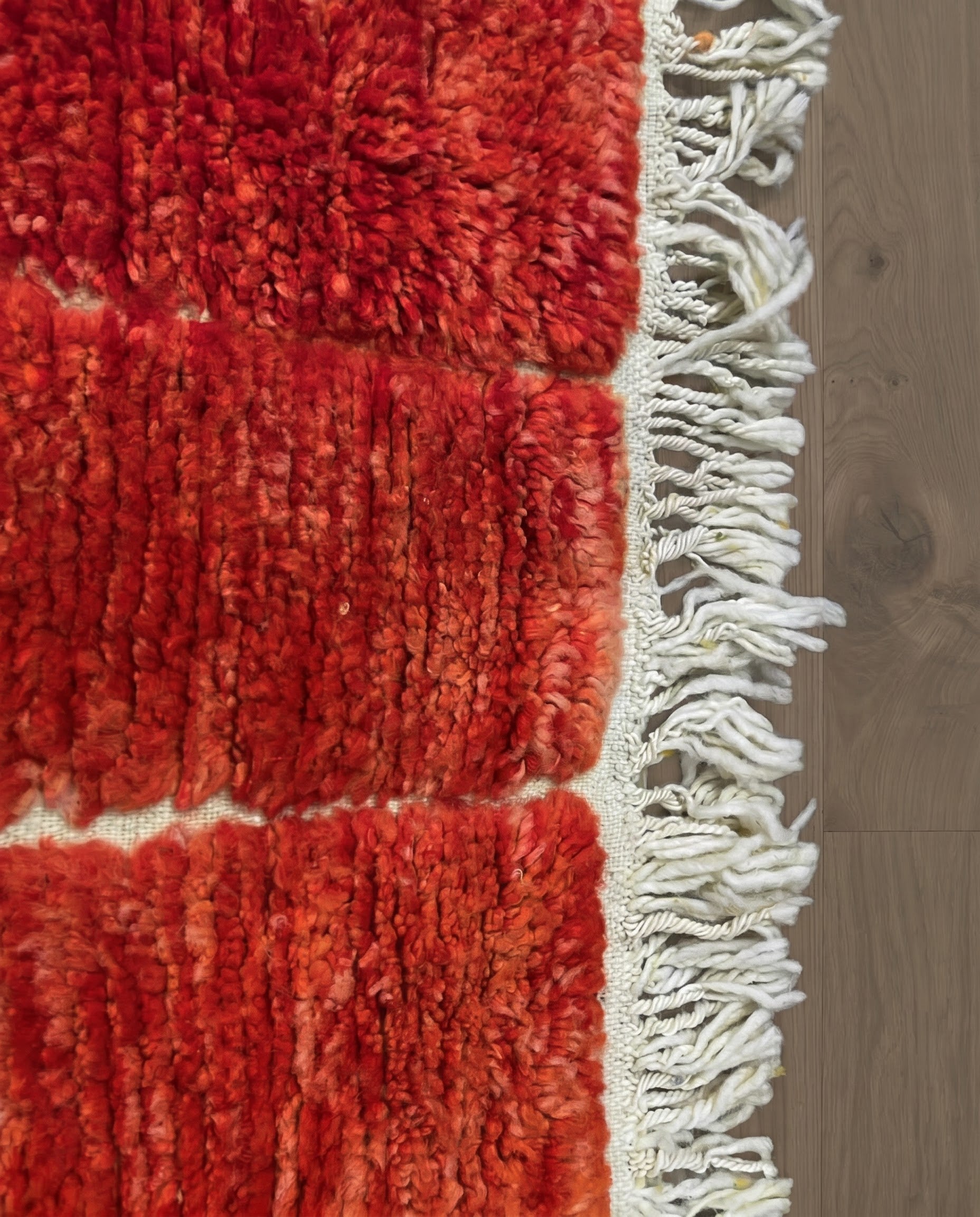 FATIMA Beni Ourain crimson organic abstract Moroccan rug close-up of hand-tied fringe and kilim band detail, by NURA