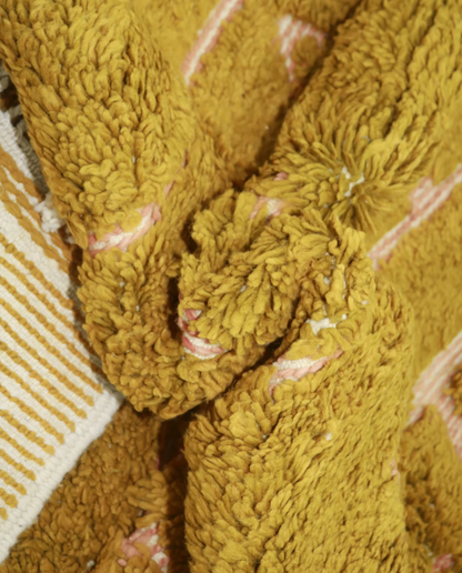 FAWZIA Azilal mustard organic abstract Moroccan rug close-up showing hand-knotted wool texture and pile detail, by NURA