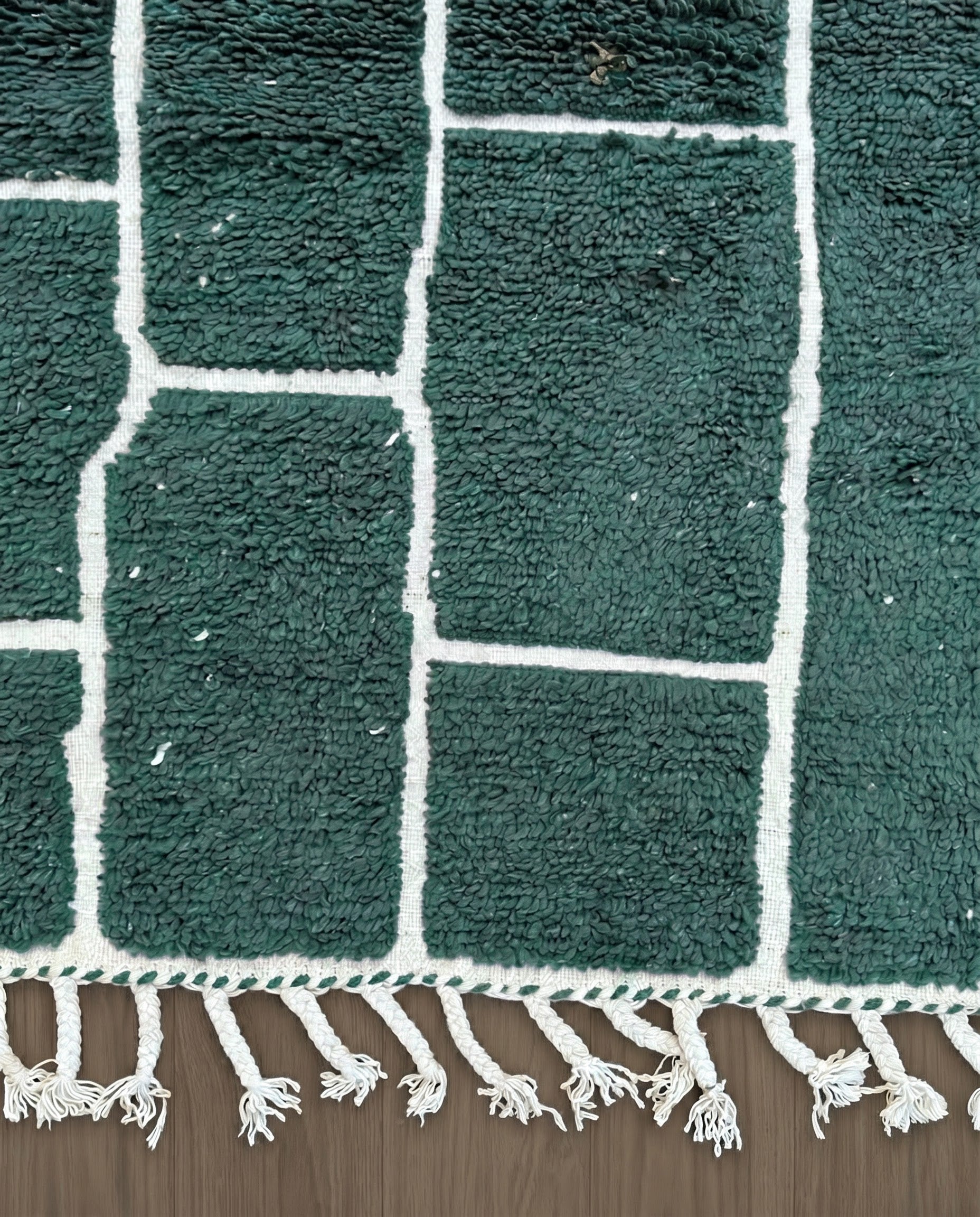 FIDA Beni Ourain forest green checker grid Moroccan rug close-up of hand-tied fringe and kilim band detail, by NURA