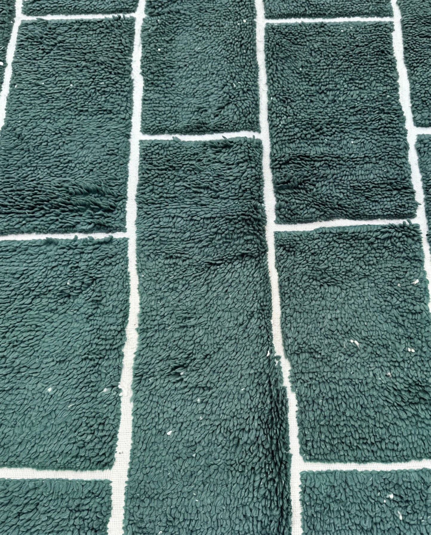 FIDA Beni Ourain forest green checker grid Moroccan rug close-up showing hand-knotted wool texture and pile detail, by NURA